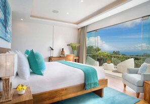 Ein modernes Hotelzimmer mit einem großen Bett, einem Schreibtisch, einem Sessel und einem Balkon mit Blick.