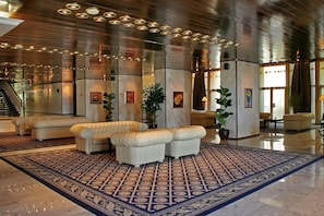 A spacious lobby with a patterned carpet, leather seating, and a staircase. - Hotel Imperial - Riviera Holiday Club Varna (Varna)