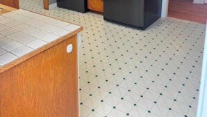Uma cozinha com armários de madeira, uma geladeira de aço inoxidável, um micro-ondas e um forno.
