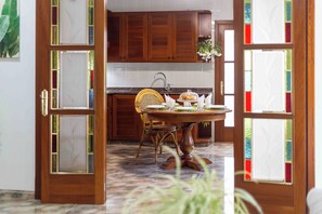 A dining area with a round table, chairs, and a kitchen in the background. - Fantastic villa with pool in Puerto de Alcudia (Port d'Alcúdia)