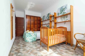 A room with a crib, a wardrobe, a shelf with plants, and a chair. - Fantastic villa with pool in Puerto de Alcudia (Port d'Alcúdia)