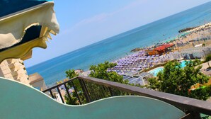 Un resort costero con piscina, playa y una gran escultura.