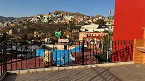 A rooftop terrace with a view of a hillside town.
