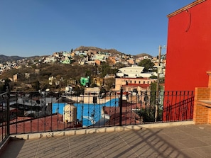 Una terraza en la azotea con vistas a un pueblo en la ladera de una colina.