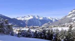 Un pueblo cubierto de nieve con montañas al fondo.