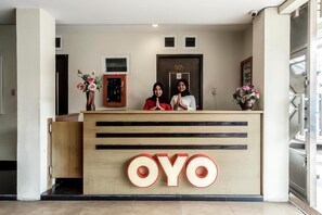 A reception desk with a large 'OYO' logo, a door with a number, and a security camera. - Goelia - Les Balcons D'anaes (Villarodin-Bourget)