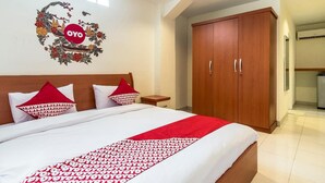 Una habitación de hotel con una cama, un armario y un adorno en la pared.