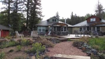 A cabin with a patio area, outdoor seating, and a garden.