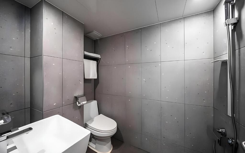 A modern bathroom with a toilet, a sink, and a shower.