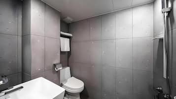 A modern bathroom with a toilet, a sink, and a shower.