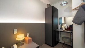 Un baño moderno con un espejo de cuerpo entero, un perchero, un lavamanos y un inodoro.