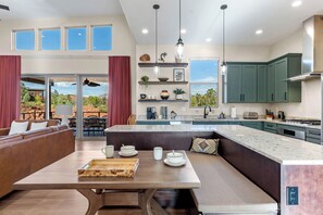 A modern kitchen with a large island, built-in appliances, and a view of the outdoors. - New Luxury Home – Special Introductory Pricing for a Limited Time. (Sedona)