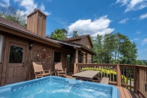 A wooden house with a hot tub, deck chairs, and a compass on the wall. - Hunter Jacks: Hot Tub, Mnt Views, Foosball (Sevierville)