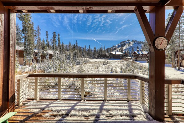 A wooden deck with a snow-covered landscape and a clear sky.