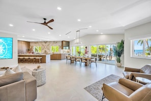 A spacious living area with a modern kitchen, dining space, and a view of the outdoors.