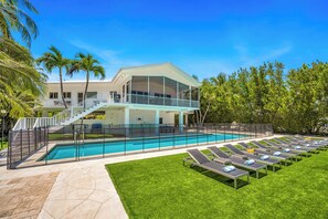 A modern two-story house with a swimming pool, a covered patio, and a lawn with sun loungers. - PRIVATE BEACH  / Heated Pool / Private Dock / Dolphin Key (Islamorada)