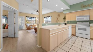 Una cucina moderna con mobili in legno, un piano cottura bianco e una grande isola con lavello.