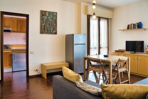 Un espacio habitable compacto con kitchenette, comedor y asientos.