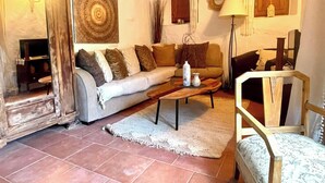 En stue med en sofa, et sofabord, en lampe og et spejl.