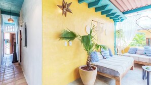 A room with a bed, a large potted plant, a wall-mounted star decoration, and a macrame wall hanging. - Pool Access • Walk to Beach • Kitchen • 
SAYULITA BOUTIQUE SUITES - 2 (Sayulita)