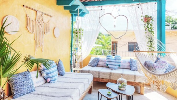 A cozy outdoor seating area with a hammock, cushions, and a small table. - Pool Access • Walk to Beach • Kitchen • 
SAYULITA BOUTIQUE SUITES - 2 (Sayulita)