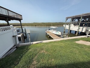A dock with a boat, a covered area, and a grassy area. - Cozy Condo with Pool - Walk2Beach - Boat Slip - Sleeps 4 (Corpus Christi)