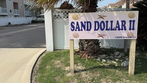 A sign for 'SAND DOLLAR II' with a beach theme, located at 14898 Granada Dr. - Cozy Condo with Pool - Walk2Beach - Boat Slip - Sleeps 4 (Corpus Christi)