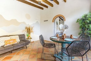 A dining area with a round table, black wire chairs, and a decorative mirror above it. - Pool Access • Walk to Beach • Kitchen • 
SAYULITA BOUTIQUE SUITES - 3 (Sayulita)