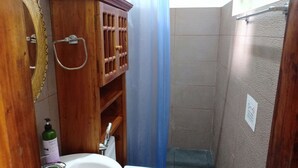 A small bathroom with a wooden cabinet, a white sink, and a toilet.
