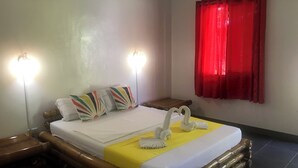 A hotel room with a bed, two bedside lamps, a red curtain, and a decorative swan on the bed.