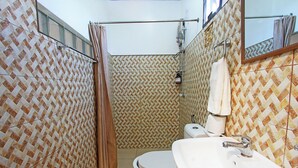 A bathroom with patterned tiles, a toilet, a sink, and a shower area. - Beautiful, spacious, resort with a secluded garden. (Santander)