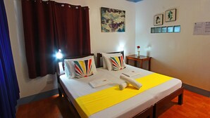 A hotel room with a bed, curtains, a painting, a small table with a vase, and a wall with framed pictures. - Beautiful, spacious, resort with a secluded garden. (Santander)