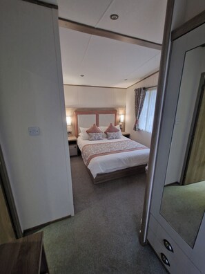 A hotel room with a bed, bedside tables, a wardrobe, and a mirror. - Cozy Retreat near Llanberis (Caernarfon)
