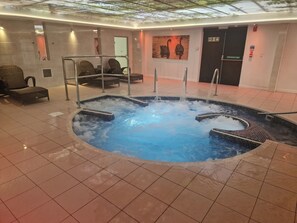 A hot tub with seating around it, a tiled floor, and a ceiling with a glass section. - Cozy Retreat near Llanberis (Caernarfon)