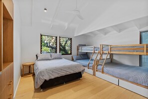 A modern bedroom with a bunk bed, a single bed, and a wooden wardrobe. - 6 Karboora Drive - Luxury holiday home with pool (Point Lookout)