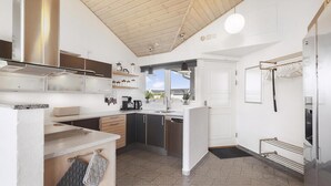 Een moderne keuken met een centraal eiland, ingebouwde kasten en uitzicht naar buiten.