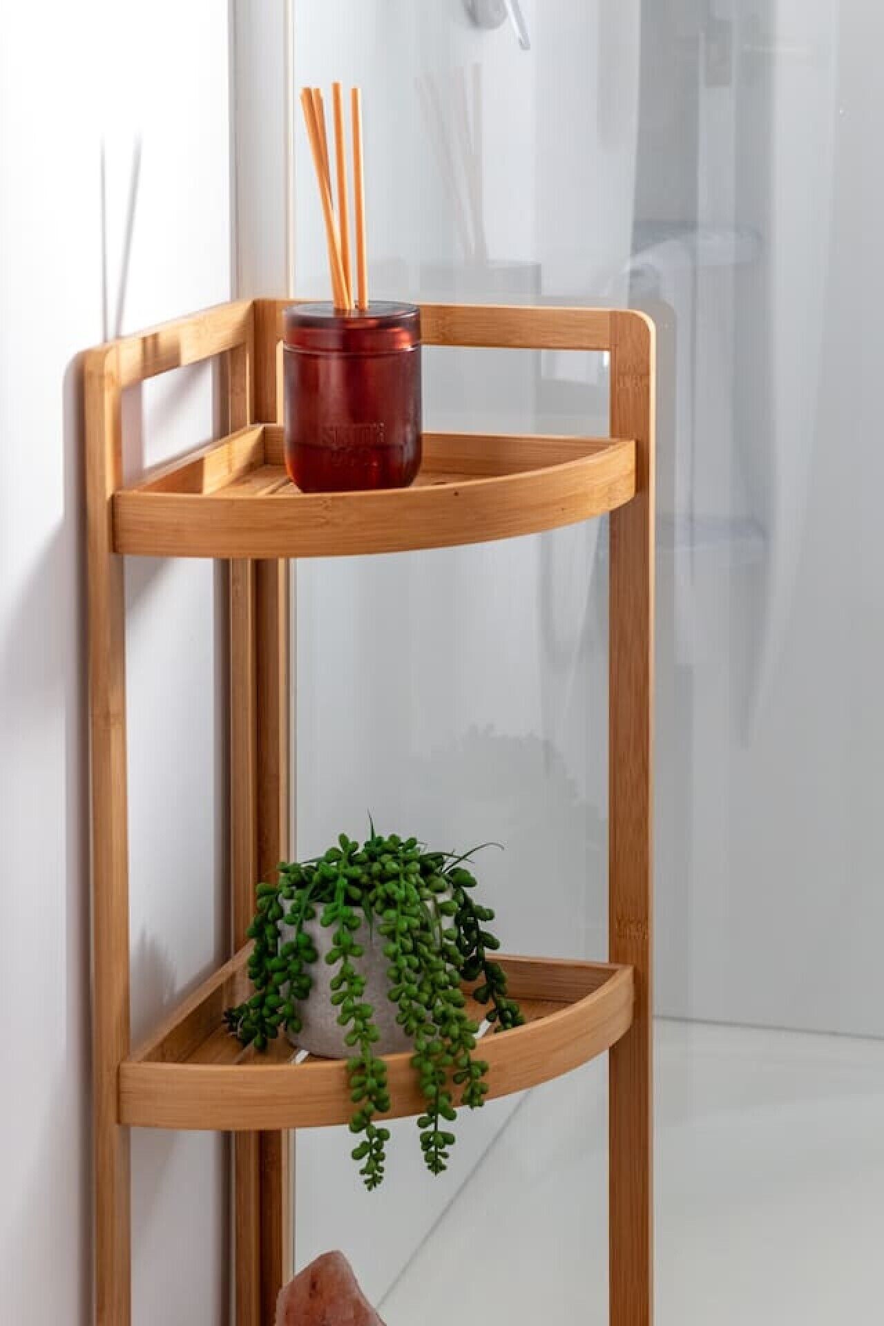 A wooden shelf unit with a red container and a green plant.
