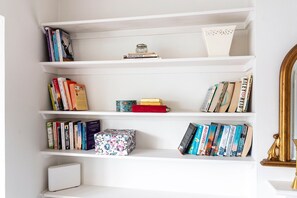 A bookshelf with various books and decorative items. - GuestReady - Modern Retreat with Classic Charm (London)
