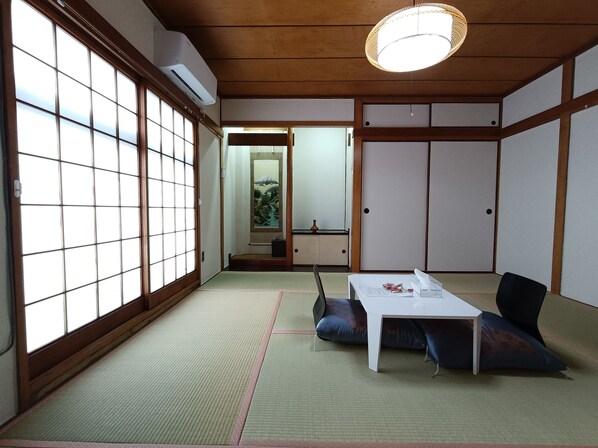 Una habitación japonesa tradicional con suelo de tatami, una mesa baja y un puertas correderas.