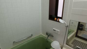 A bathroom with a green bathtub, a white sink, and a mirror above the sink.