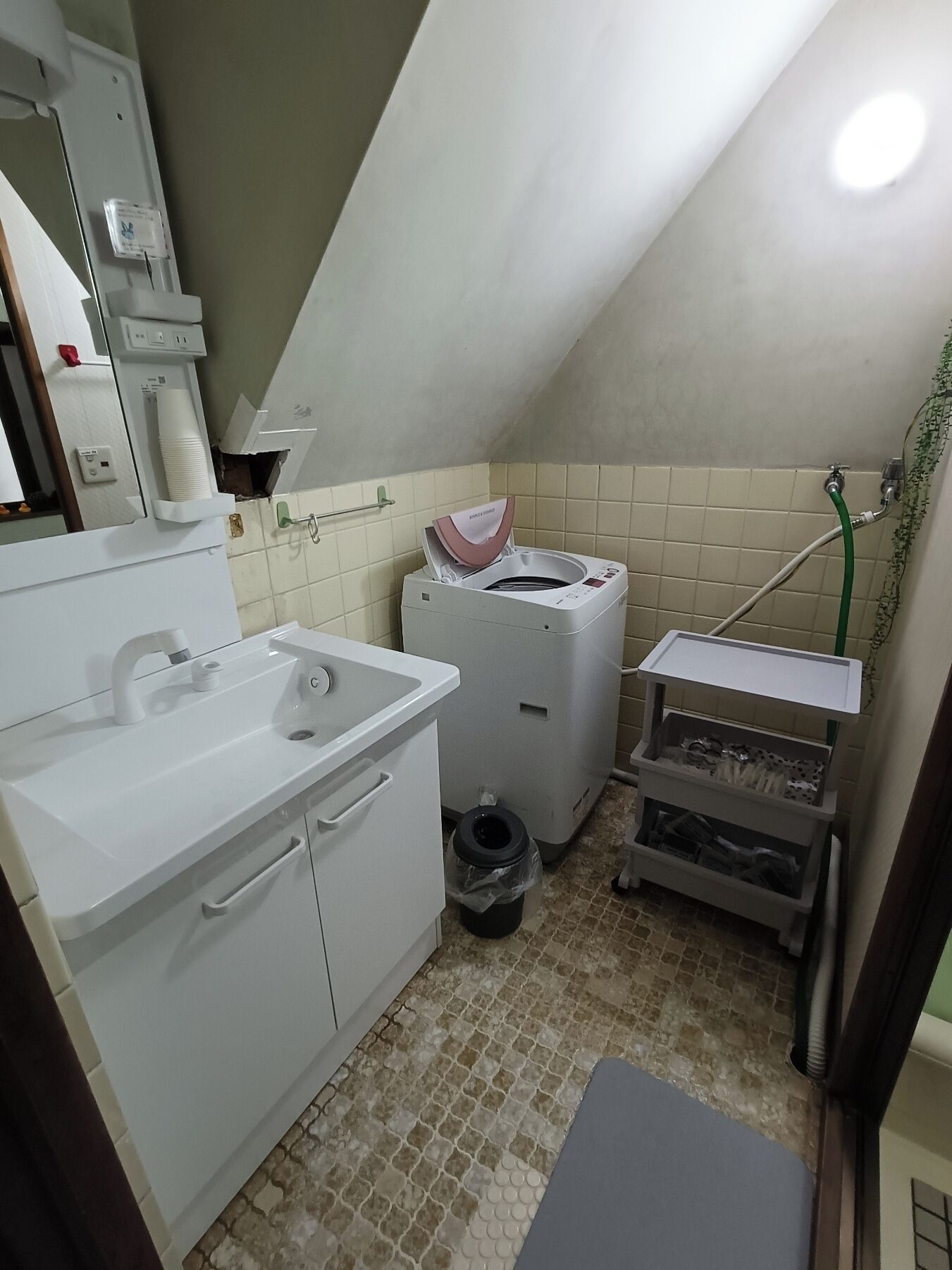 A small, compact bathroom with a sink, toilet, and shower.