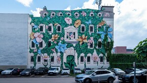 Un edificio con un mural de flores y ventanas.