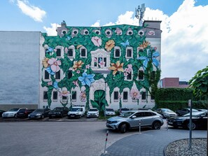 A building with a mural of flowers and windows. - Targowa Elegant Apartment (Łódź)