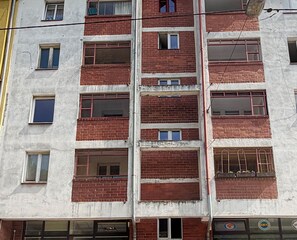 Ein mehrstöckiges Gebäude mit Fenstern und einer Ziegel-Fassade.