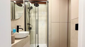 A modern bathroom with a glass-enclosed shower, a white sink, and a toilet. - Stawowa Deluxe Apartment (Wrocław)