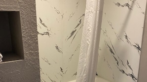 Un baño con bañera, cortina de ducha y retrete.