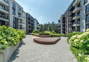 Ein moderner Wohnkomplex mit Innenhof, Balkonen und üppigem Grün.