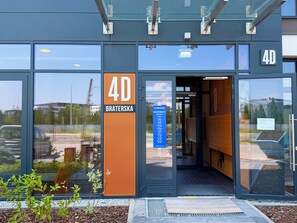 A modern building entrance with a sign indicating '4D BRATERSKA' and a directory for 'BUDYNEK KI.' - Wrocław Partynice Cosy Apartment (Wrocław)