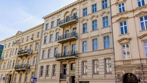 En byggnad med flera våningar, balkonger, stora fönster och en klassisk arkitektonisk stil.