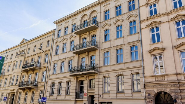Un edificio de varios pisos con balcones, ventanas amplias y un estilo arquitectónico clásico.